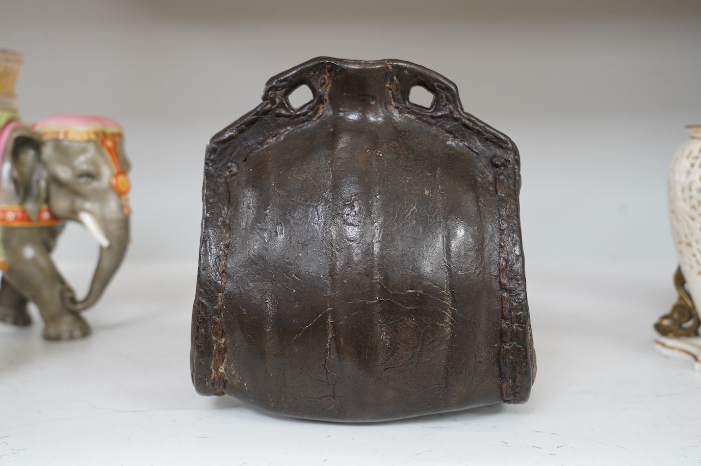 An 18th century leather cider costrel, 18cm tall. Condition - large hole cut out of one side